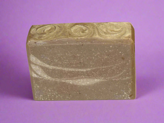 Nourishing handmade soap with a unique chocolate and lavender scent on a purple background.